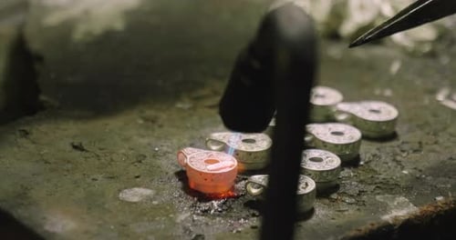 Nahaufnahme einer Hand eines Goldschmieds, der ein kostbares Juwel mit wertvollen Diamanten baut. Um das zu machen