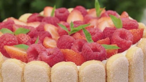 Berry raspberry and strawberry pie with mint. Savoiardi cookies. Rotation. Close-up.