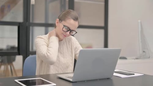 Young Woman having Neck Pain in Office