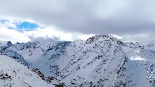 Majestätische Luftaufnahme der schneebedeckten Alpen. Hoch aufragende Gipfel erstrecken sich über den Horizont