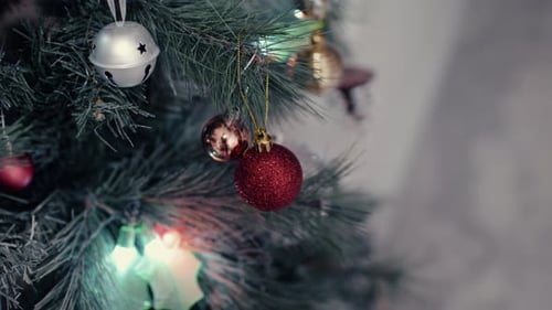 Colorful Christmas Baubles, Holly Leaf, And Ornament Lights Around Christmas Tree. - close up