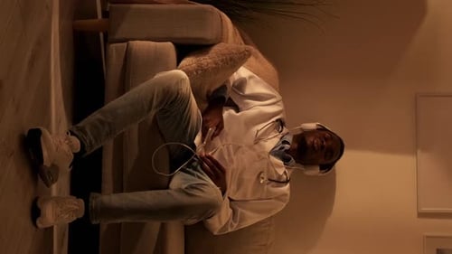 Doctor Relaxing on Couch with Headphones at Home