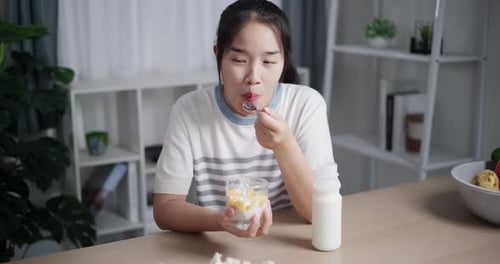 Young Woman Enjoying Healthy Yogurt Snack at Home