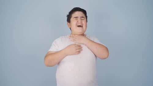 Teen Boy with Sore Throat Holds Neck