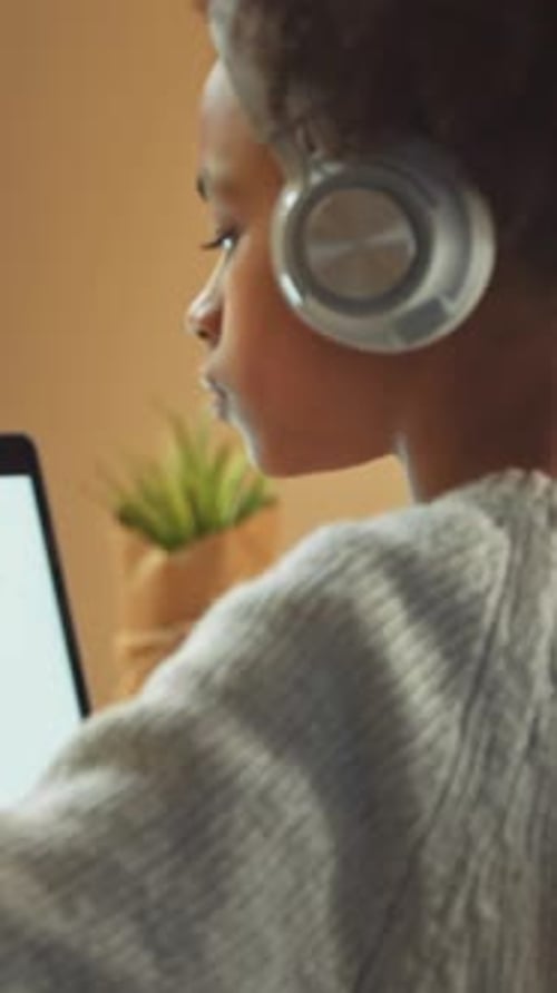 Vertical Video Dark Skinned Girl Sits at a Desk and Study Online Using a Laptop Learns in a Remote