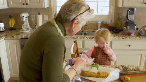 Toddler and Senior Baking Cookies Together in Kitchen