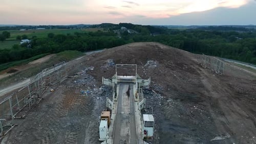 Landfill dump site for garbage disposal. Aerial flight over tilting equipment.