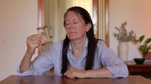 A Woman Holds an Hourglass as Time Elapses - Close Up