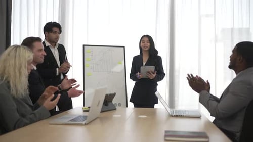 Business Team Applauding Presentation in Modern Office Setting