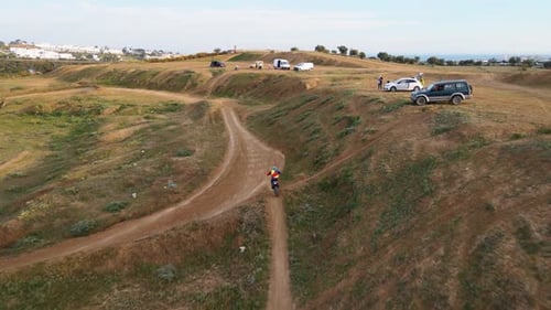 Aerial dolly tracking shot of a motorcyclist on a dusty motocross track in Malaga in Spain with dust