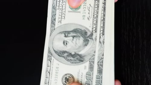 Hands counting dollar banknotes on black background, close up. Vertical video