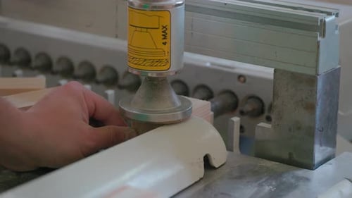 A man works with wood in a workshop. Working with wooden blanks. A man drills holes in wooden blanks