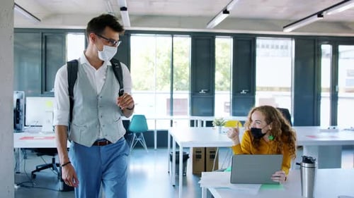 Young People with Face Masks Back at Work in Office After Lockdown