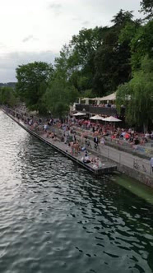 Aerial video of people enjoying themselves on the riverside in Zurich. Switzerland