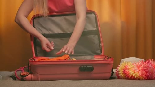 Woman Packing Suitcase on Sofa
