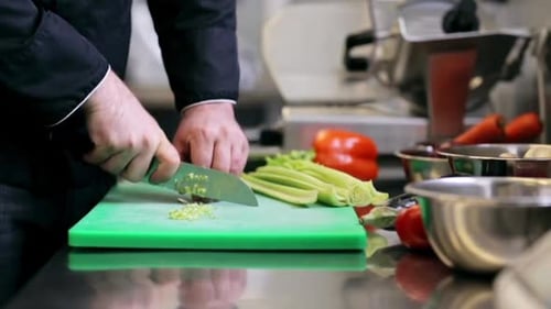 Chef Dices Celery on Cutting Board in Kitchen