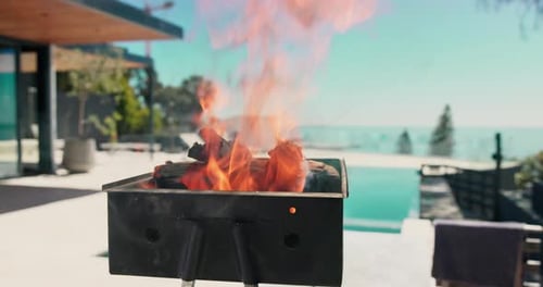 Empty, pool and bbq with flames in backyard for party, holiday and lunch on weekend outdoor