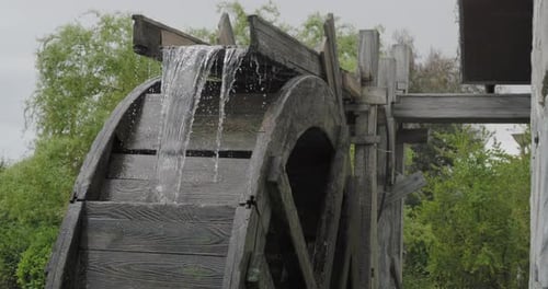 Stream of Flowing Water Turns the Wooden Wheel of an Old Water Mill