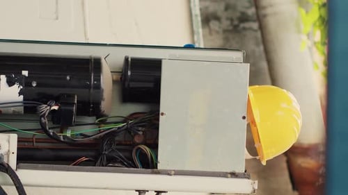 Air Conditioning Unit Partially Disassembled with Hard Hat