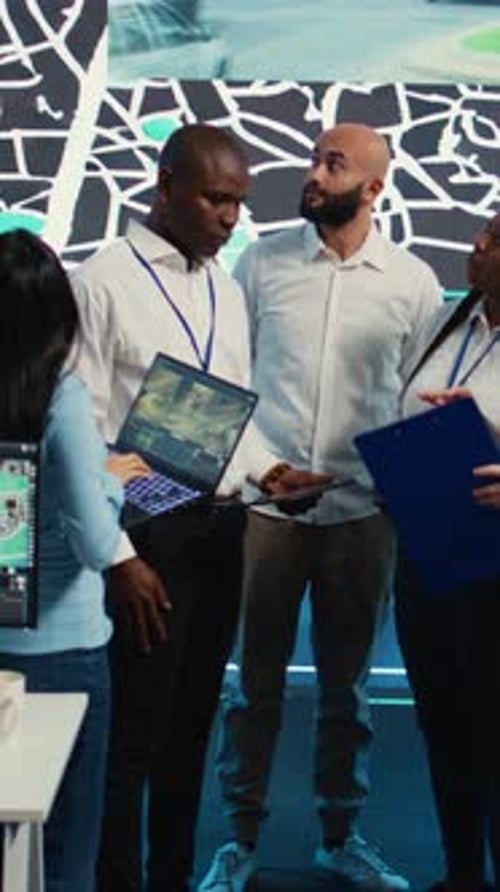 Four Adults Collaborate in Front of Digital Display