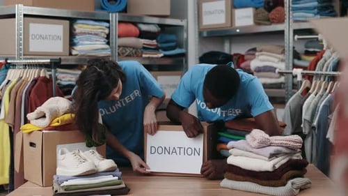 Diverse Volunteers Putting Paper with Donation Word at the Cupboard Box in Community Charity