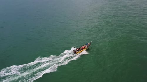 Aerial birds eye view capturing small traditional fishing boat sailing on the sea, Lumut, Pangkor is