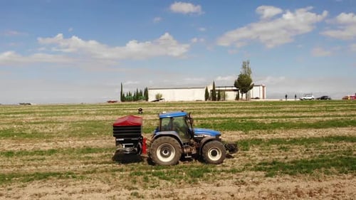Tractor Spreads Fertilizer on Farm Field