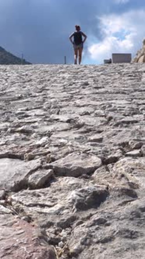 Hiker Walking Up an Ancient Cobblestone Road in Mycenae