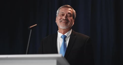 Smiling Man Giving a Speech at Podium