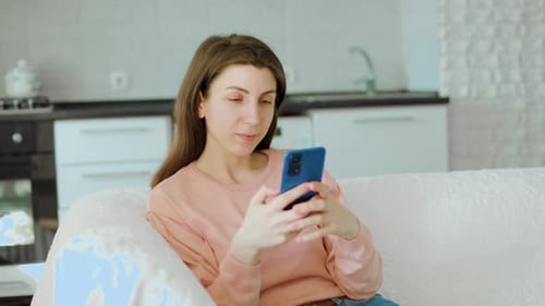 Young Woman Using Phone on Couch Indoors