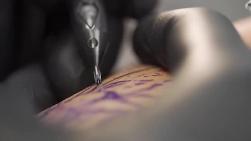 shot of tattooing process in a professional tattoo studio. Shot in slow motion 120fps