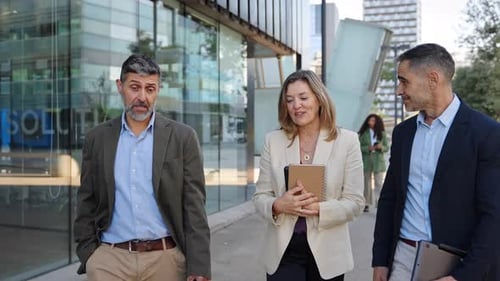 Business Partners Discussing a Project While Walking Outside Office After Work in the City