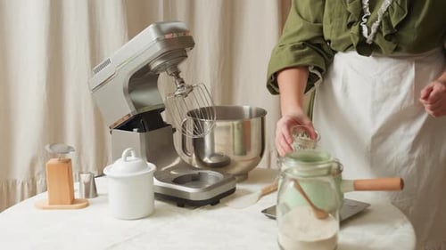 Cook Pouring Water Into Mixing Bowl During Kitchen Preparation