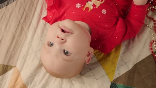 Delightful Infant Lying on Blanket with Christmas Beads