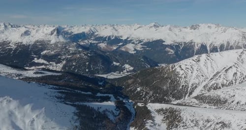 Snowy Peaks And Forested Mountainside