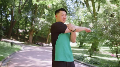 Japanese Sporty Healthy Man Athlete in Park Outdoors Stretching Hands Stretch Arms Morning Workout