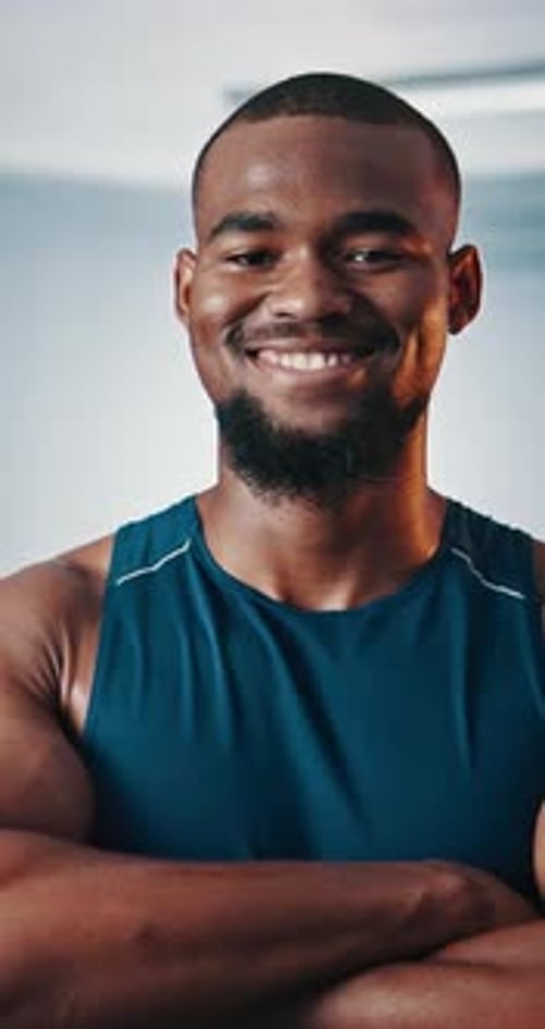 Black man, face and arms crossed in gym for training, strength or muscle building for fitness club