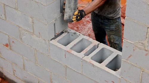 Man Working on Concrete Block Wall Construction