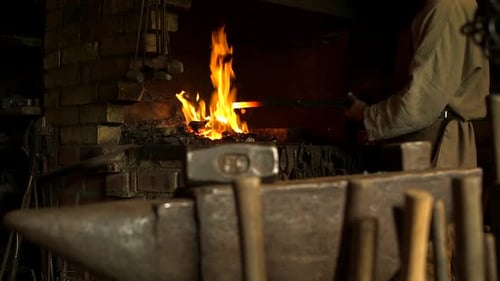 Der Schmied holt Rod aus dem Feuer und beginnt, ihn auf dem Amboss zu schmieden.