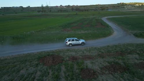 SUV Driving on Dirt Road in Rural Countryside