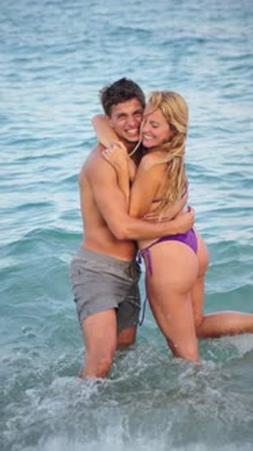 Joyful Couple Enjoying a Romantic Moment Together While Splashing in the Refreshing Ocean Water