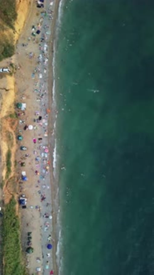 Aerial View of Sandy Beach Swimming People in Sea Bay with Transparent Blue Water at Sunset in