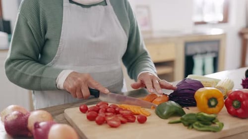 Adult Slicing Carrots with Vegetables in Bright Kitchen