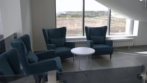 Armchairs with Low Round Table Under Staircase in Office