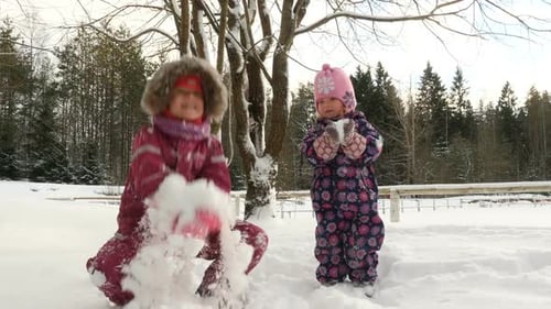 Kinder spielen im Tiefschnee. Kleine Mädchen gehen an sonnigen Wintertagen im Freien spazieren.