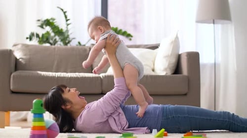 Woman playing with baby on living room floor