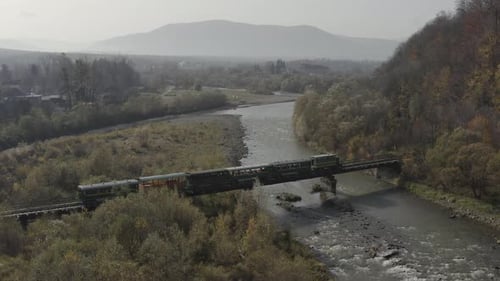 Aerial View of a Train Traveling Over a Railway Bridge Over a River