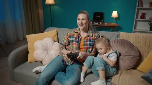 Woman and Child Playing Video Games on Sofa