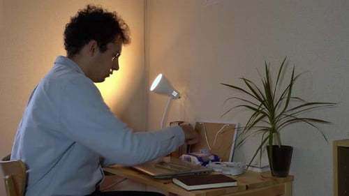 A Male Employee Cleaning His Smartphone With Moist Wipe At His Home Office During The Pandemic Coron