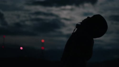 Silhouetted Figure Gazing Up at Night Sky